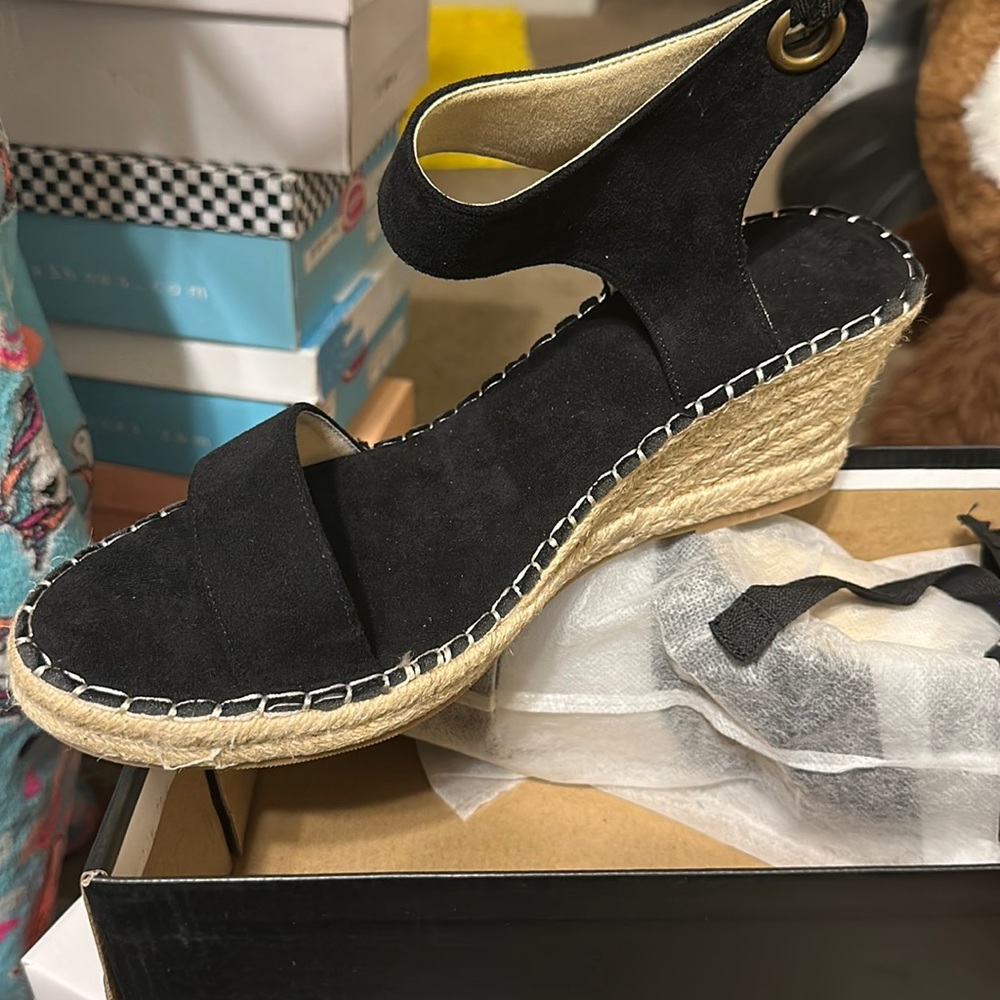 Black espadrilles with straps that ties around the ankles and legs